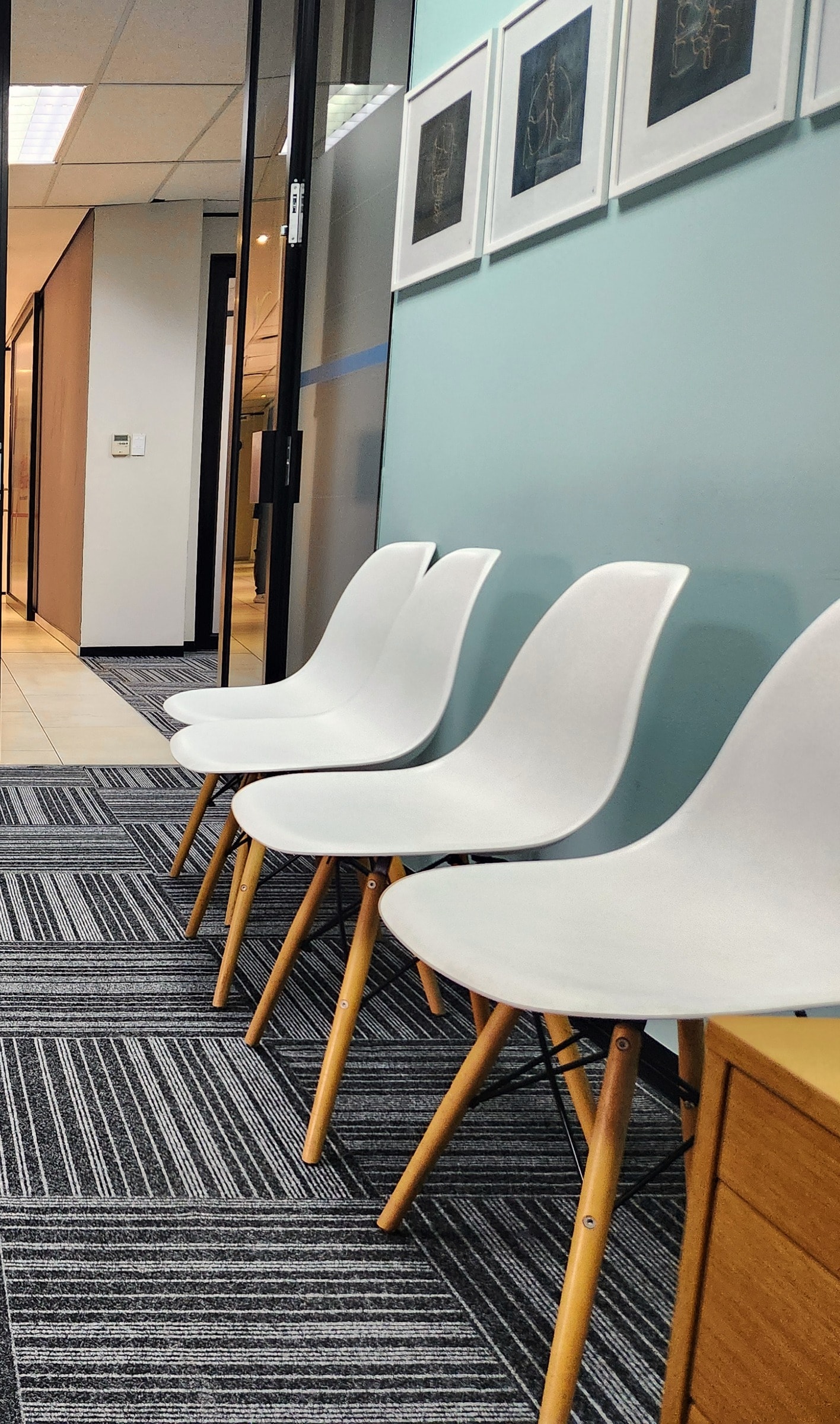 White chairs along the mint wall of the waiting area