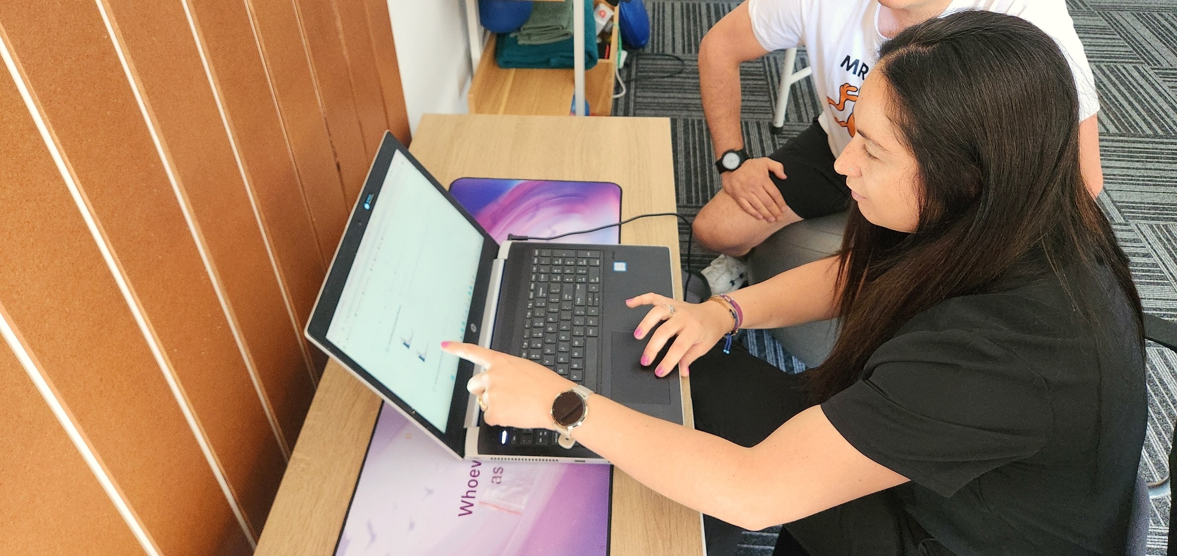 Cayla going through results with a patient at her laptop