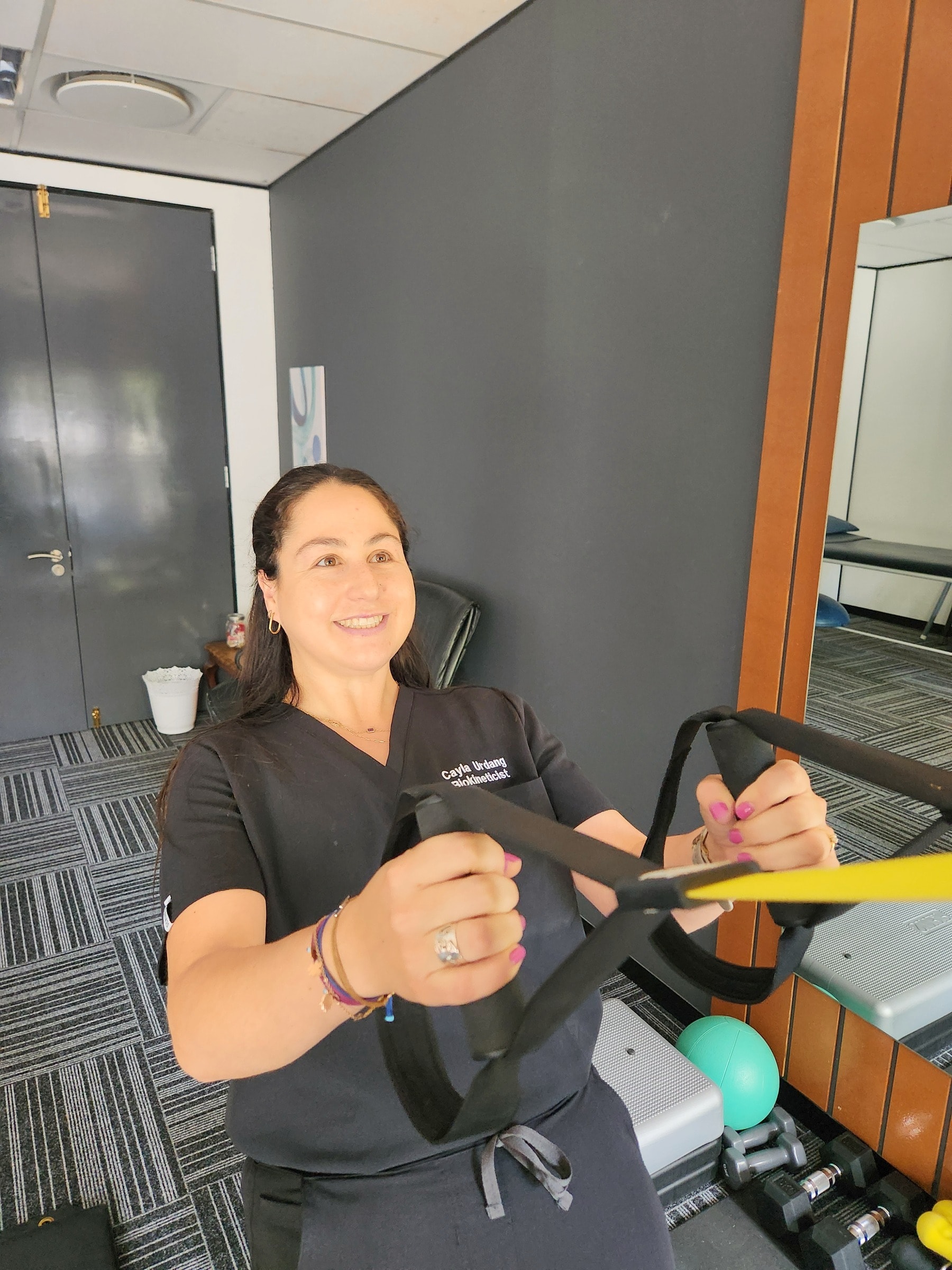 Cayla demonstrating an exercise with suspension straps
