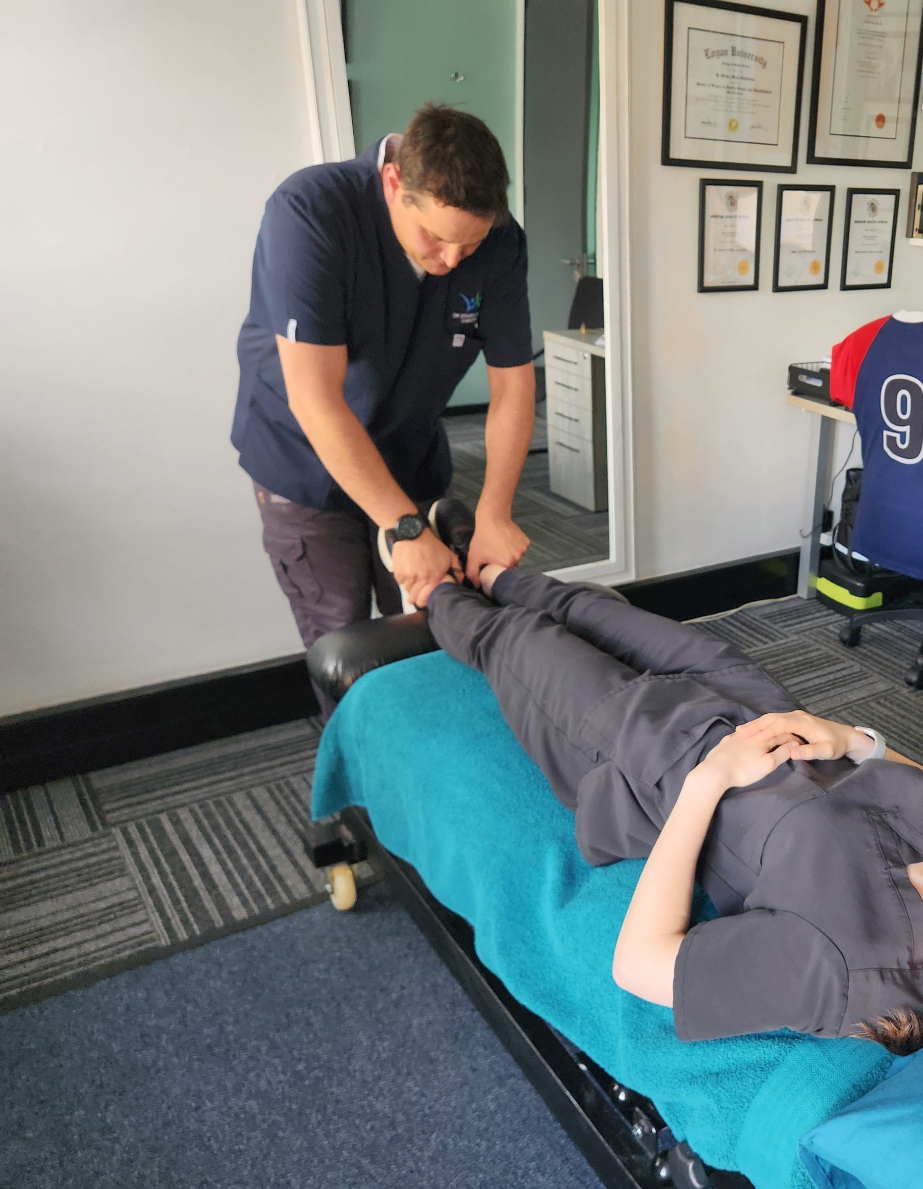 Steven working at a patient's ankles on the treatment table